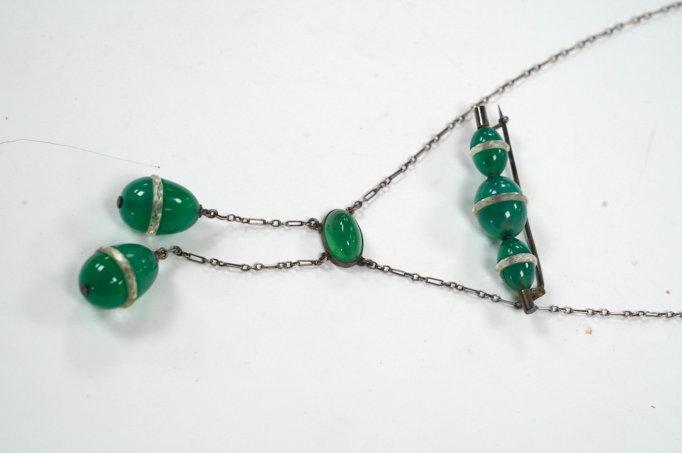 A white metal and green paste set double drop pendant necklace, 54cm and a similar brooch. Condition - fair to good